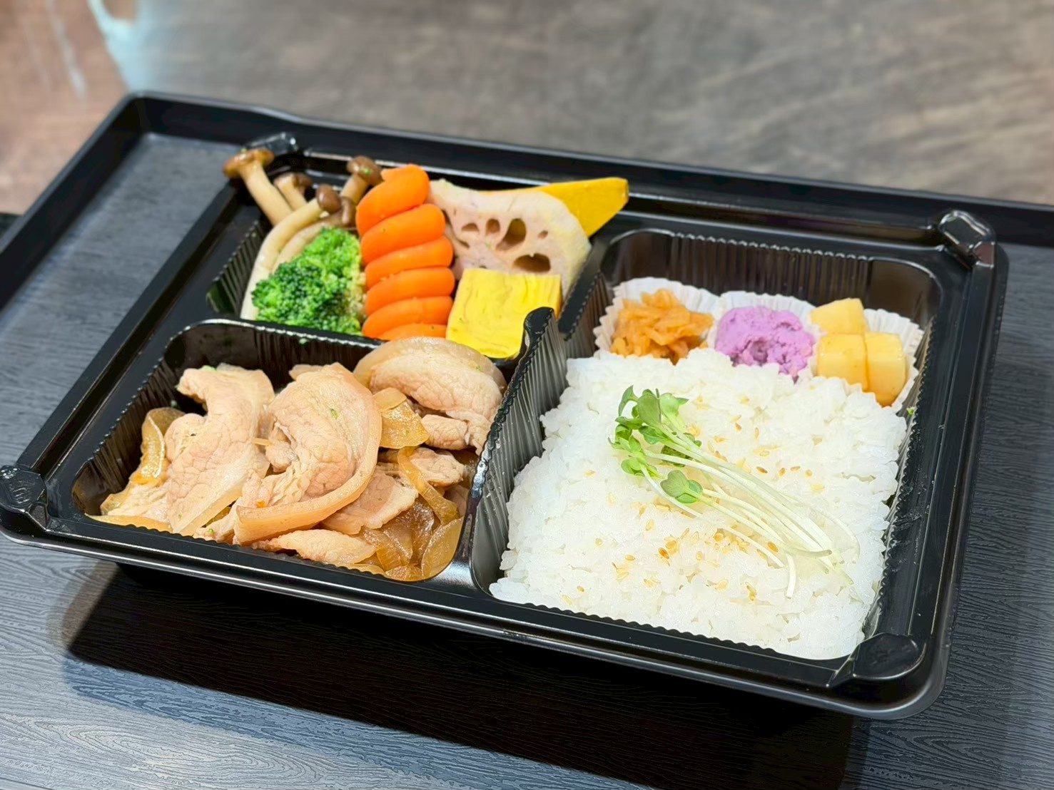 ข้าวกล่องบูตะด้ง หมูสไลซ์กับหอมใหญ่ในซอส วางคู่ข้าวญี่ปุ่นโรยงาและผักต้มหลายอย่าง