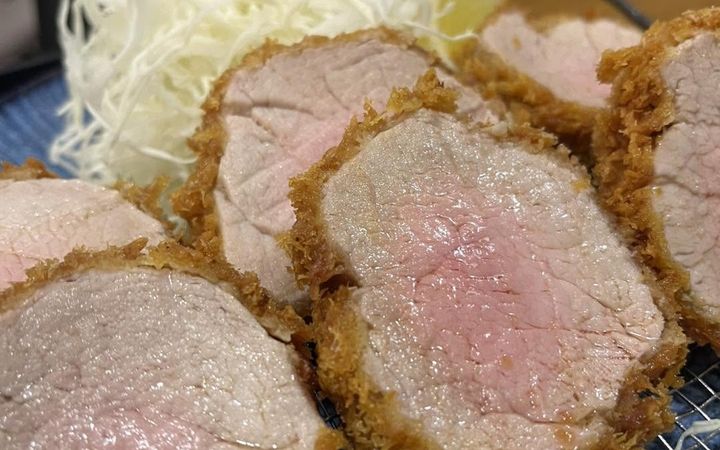 ทงคัตสึหมูสันในหั่นชิ้น หน้าตัดสีชมพู เสิร์ฟกับกะหล่ำปลีซอย